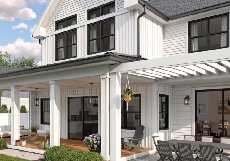 White farmhouse with black-framed windows and sliding patio doors opening onto a covered porch